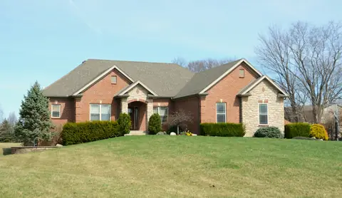 Clean brick ranch home with bright siding on a sunny day